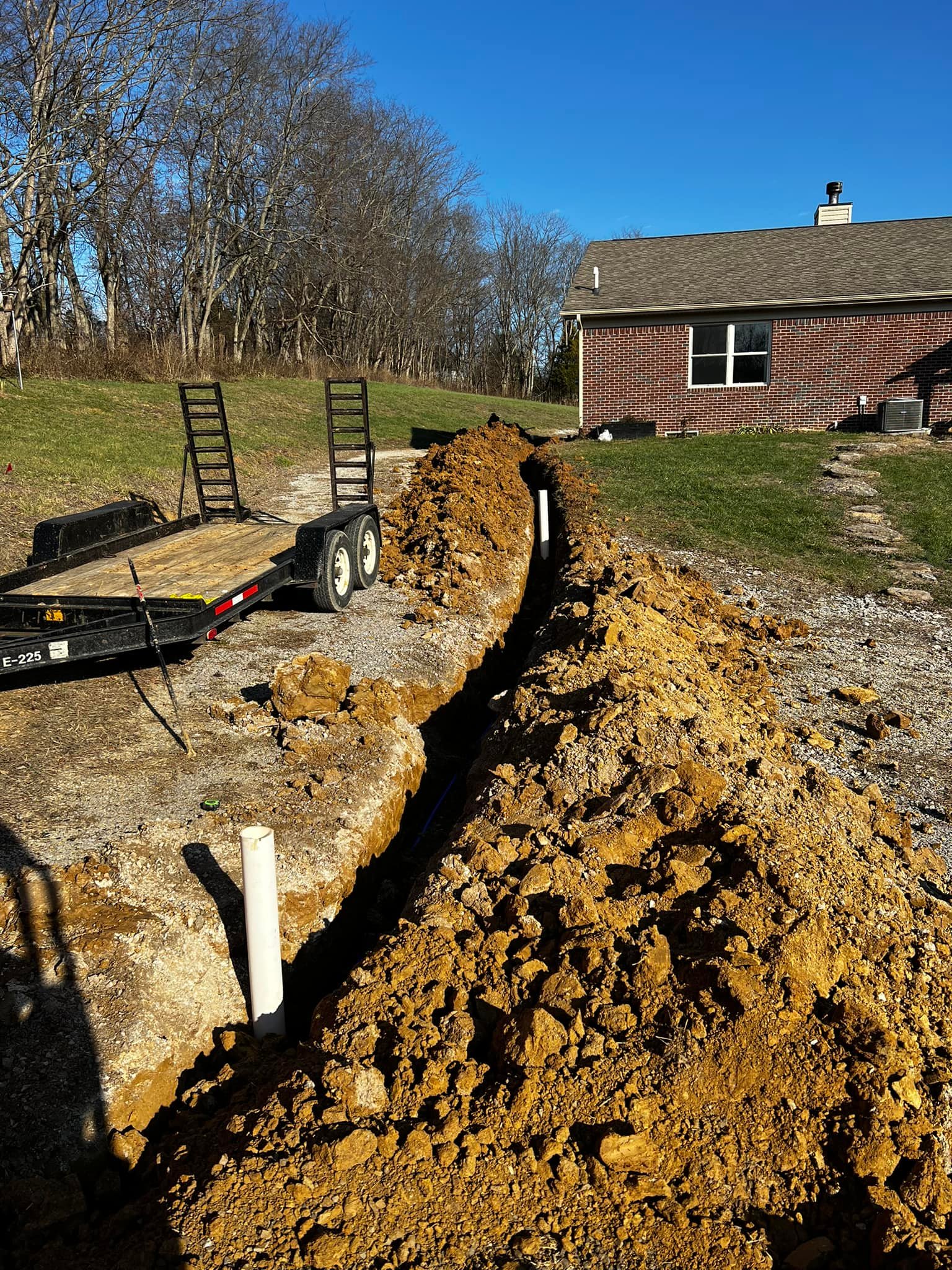 Livestock waterline trench with supply pipes sticking up, ready for connecting to waterers.